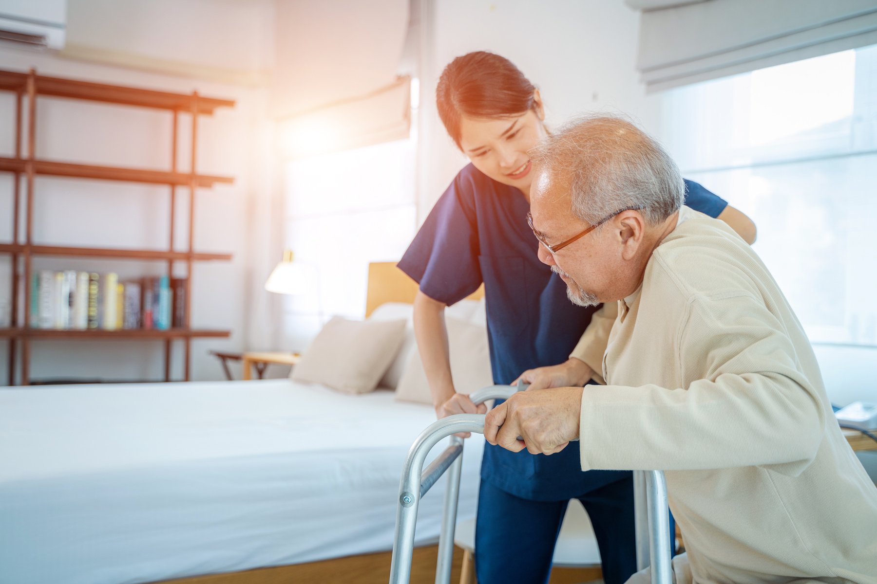 Nurse helps senior man practice walking at nursing home,Caregive